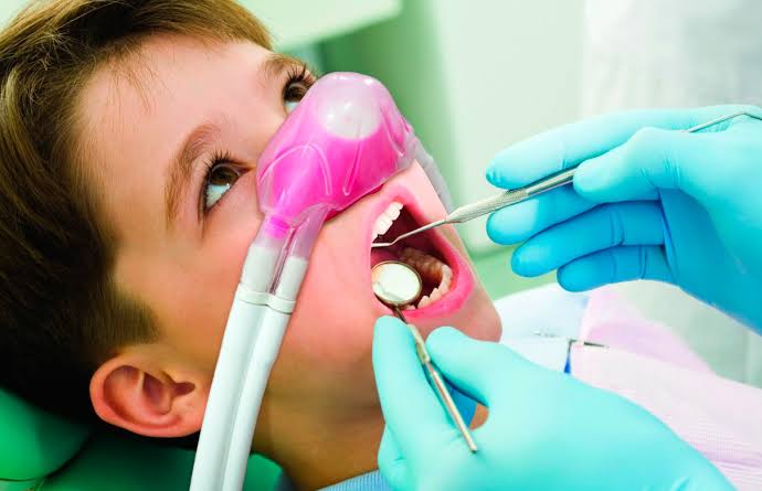 Criança sorrindo e tranquila na cadeira odontológica durante o atendimento
